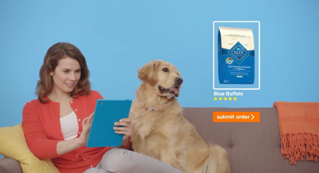 women sitting in a couch using a tablet next to a golden retriever dog
